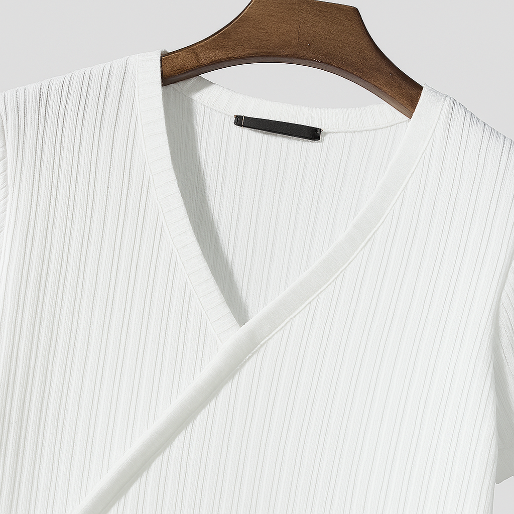 White ribbed knit V-neck sweater hanging on a polished wooden hanger against a light gray background