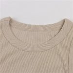 Close-up of a beige ribbed round neckline on a sleeveless top with clean stitching.