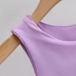 Light purple sleeveless top on a curved wooden hanger, showcasing smooth fabric texture.