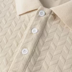 Close-up of a beige chevron-textured polo shirt showing three white buttons and a structured collar with contrasting knit.