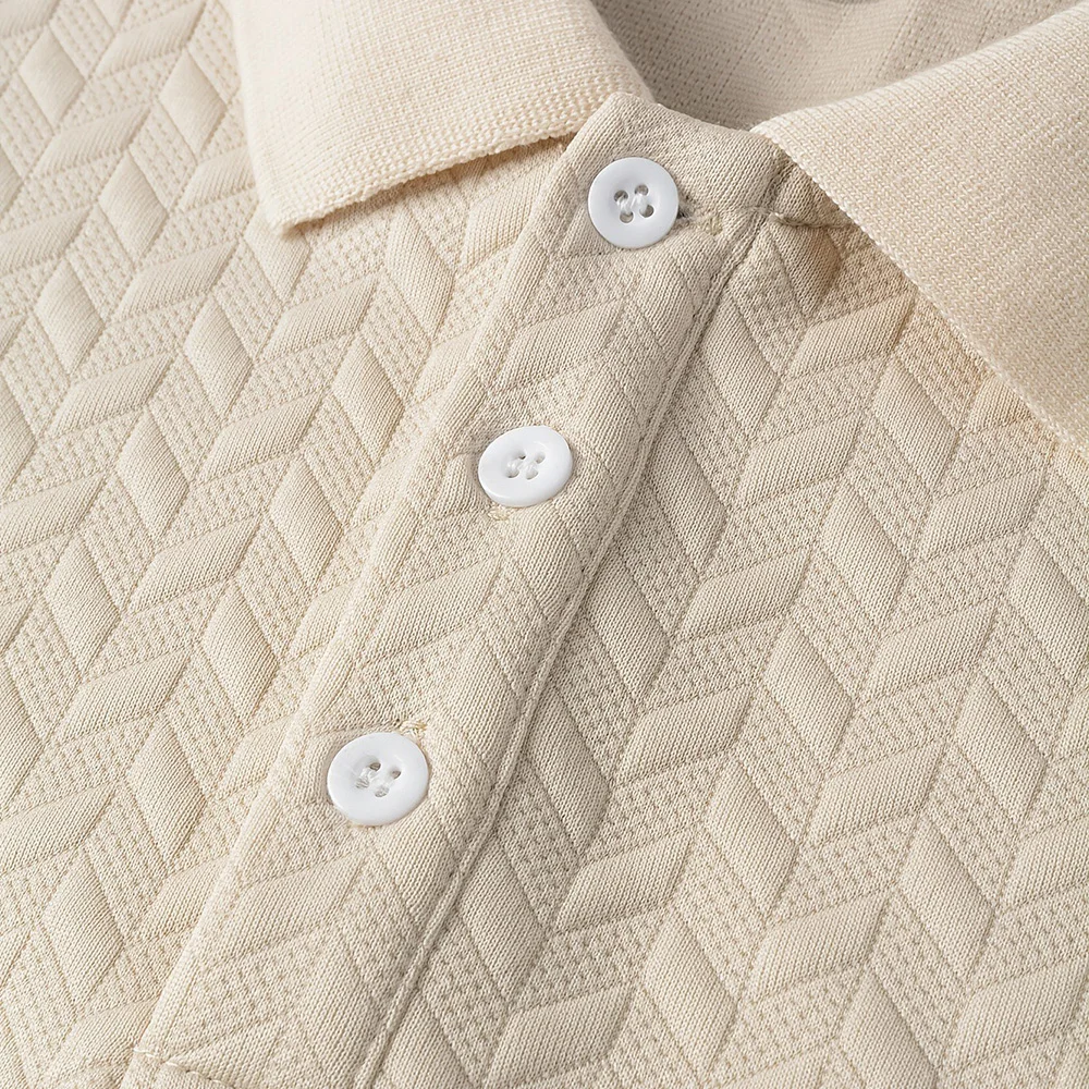 Close-up of a beige chevron-textured polo shirt showing three white buttons and a structured collar with contrasting knit.