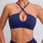 Woman wearing a deep navy crisscross sports bra with keyhole front, styled for activewear