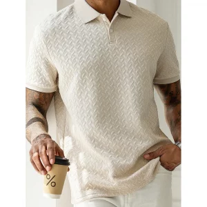 Model wearing a beige chevron-textured polo shirt, holding a minimalist coffee cup with a percentage symbol.