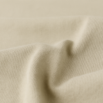 Close-up of beige knit fabric with soft folds and fine texture.